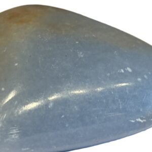 Polished natural angelite carved heart crystal 1 sians emporium Smooth polished blue angelite carved heart crystal showing natural white mineral flecks on a white background